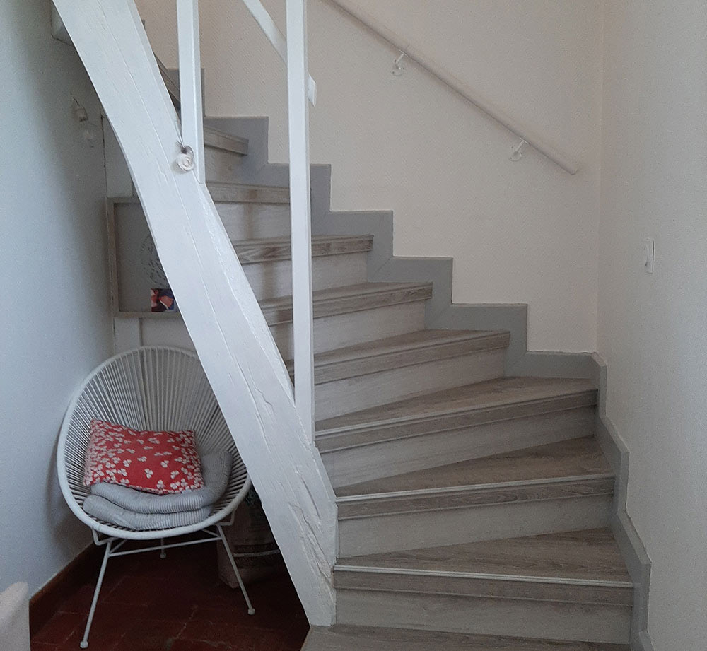 Escalier blanc et gris avec poutre en bois après travaux